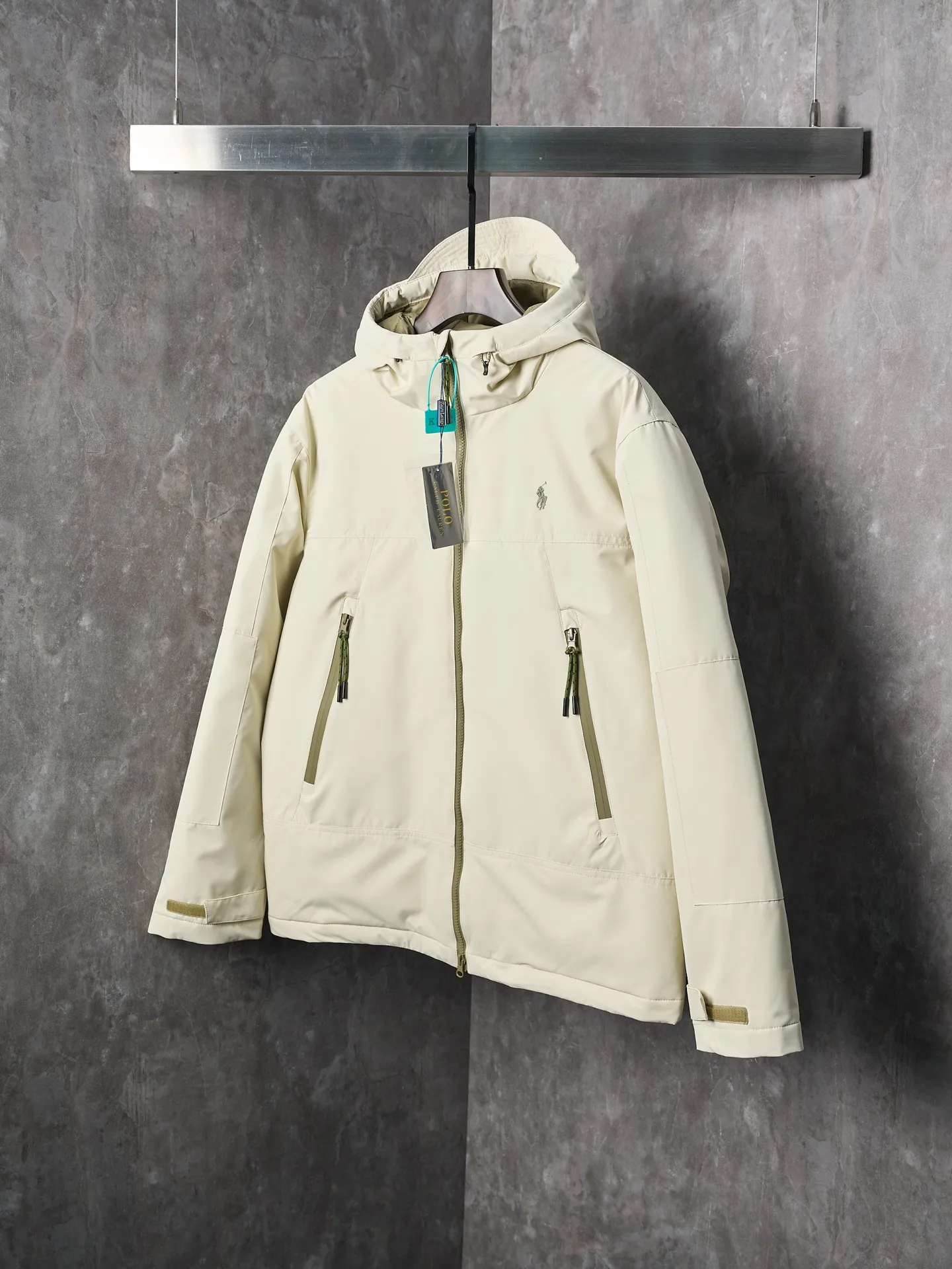 P980 Actual auction】Ralph Lauren/Ralph Lauren pony embroidered zipper hooded down jacket [Ready stock] S M L XL high-quality filling: 90 white duck down is selected, weighing 220g, ensuring excellent thermal insulation performance. After strict screening and processing, the velvet is not easy to be drilled, ensuring durability. The density of high-density nylon taffeta is about 210T-300T, with a smooth and slightly matte surface, excellent windproof and waterproof properties (with DWR water-repellent treatment), strong wrinkle resistance and easy care, in line with the positioning of American casual "durable and practical".  The inner lining is made of 100% polyamide. The high-density and tight weaving process prevents fine lint from getting out of the gaps in the fabric. The smooth surface improves the putting on and taking off experience, and the excellent wear and tear resistance ensures damage caused by frequent use, while the light and soft texture does not affect the overall weight.  The classic jacket has a slightly loose fit, slightly dropped shoulder line (shoulder width is 1-2cm wider than the standard fit), is hip-length, and has slightly tapered straight sleeves, taking into account both freedom of movement and casual style.  The adjustable Velcro on the cuffs allows you to freely adjust the tightness according to the thickness of your wrist and personal preferences, effectively preventing cold wind from intruding, and improving the warmth performance.  In terms of storage, the two front zipper pockets are convenient for you to place frequently used items, and the zipper design ensures that items are not easily lost. A built-in pocket on the left side of the chest provides a safe storage space for some small private items.  The drawstring design at the hem allows you to adjust the shape of the jacket according to your body shape and dressing needs. Whether it is loose and casual or slim and neat, you can easily control it.  Embroidery technology: Polo horse logo on the left chest: flat satin stitch embroidery (satin embroidery), embroidery thread: 100% polyester high color fastness embroidery thread (the color number is consistent with the brand’s standard red color card), stitch density 12-15 stitches/cm, the outline of the horse logo is clear, and the details of the rider and horse are burr-free.  Embroidery positioning: precise positioning through the template (12cm from the neckline and 8cm from the placket) to ensure left and right symmetry and centering.